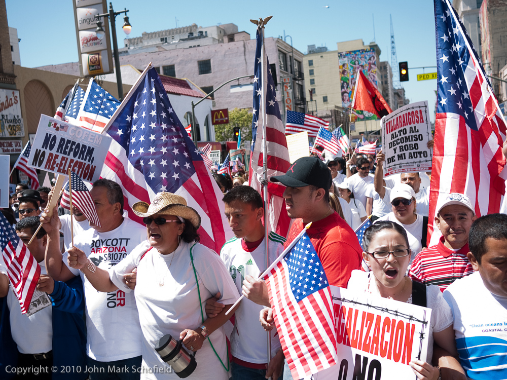 Immigration reform protestors wearing white shirts and carrying lots of flags
