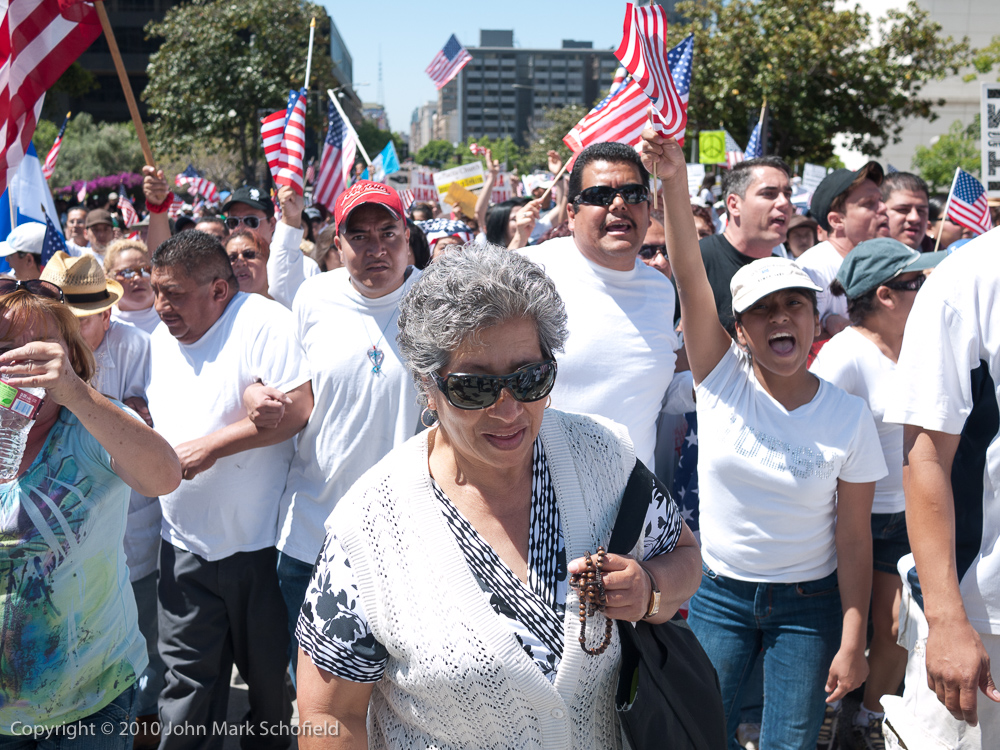 Immigration reform protestors wearing white shirts and carrying lots of flags