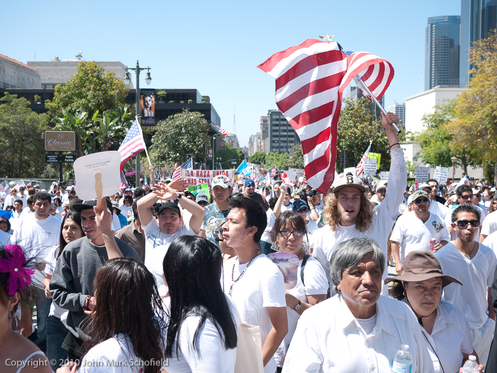 Marcher in a crowd waving an American flag